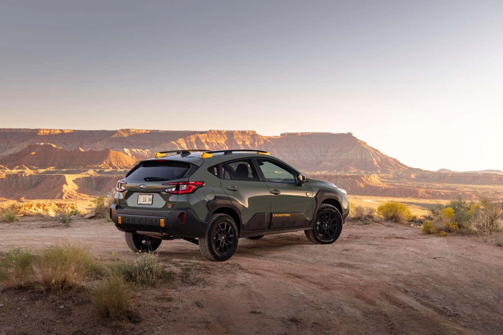 The Back Exterior Of The Fierce, Secure, And Award Winning 2024 Subaru Crosstrek Wilderness, Looking Out From A Cliff To The Many Mountains It Will Blaze