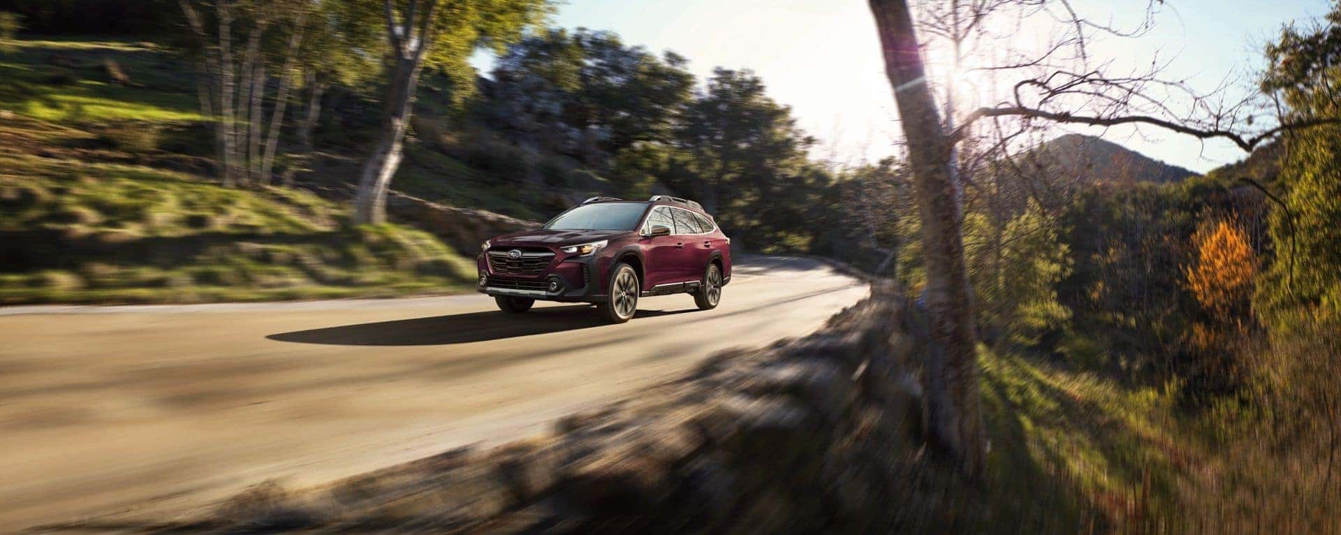 The Streaking 2023 Subaru Outback, Turning At A Bend, With A Glorious Wild Background