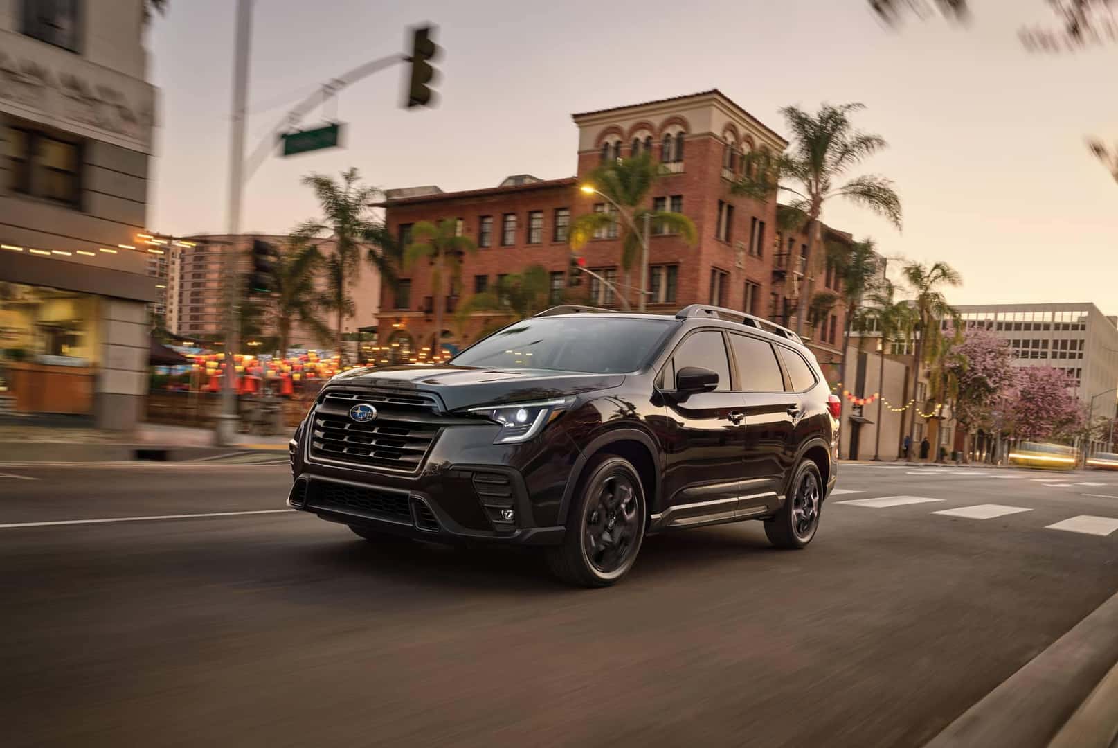 2025 black Subaru Ascent driving down a palm tree lined downtown street