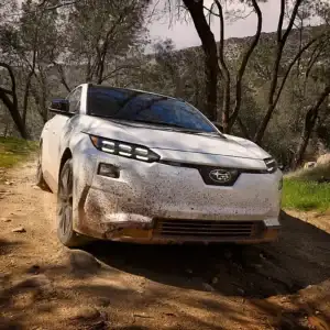 2026 Subaru Solterra Touring XT Cosmic White Pearl driving through dirt