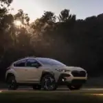 2026 Subaru Crosstrek front side view parked off road on a grass in front of trees