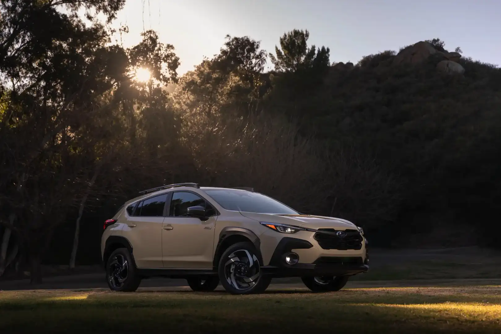 2026 Subaru Crosstrek front side view parked off road on a grass in front of trees