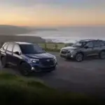 Two Subaru Foresters parked in a lot by a lake