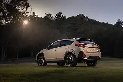 2026 white Subaru Crosstrek Hybrid view of the rear parked on grass 