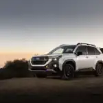 2026 Subaru Forester Wilderness view of the front parked on grass in front of a lake at sundown