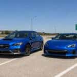 2026 Subaru WRX and 2026 Subaru BRZ parked side by side on a North Texas highway
