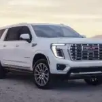 2026 GMC Yukon Denali near Ruth NC in white with chrome GMC grille, Denali badging, on desert terrain