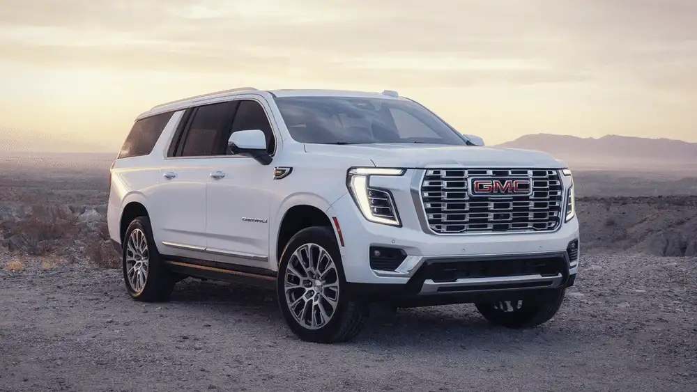 2026 GMC Yukon Denali near Ruth NC in white with chrome GMC grille, Denali badging, on desert terrain