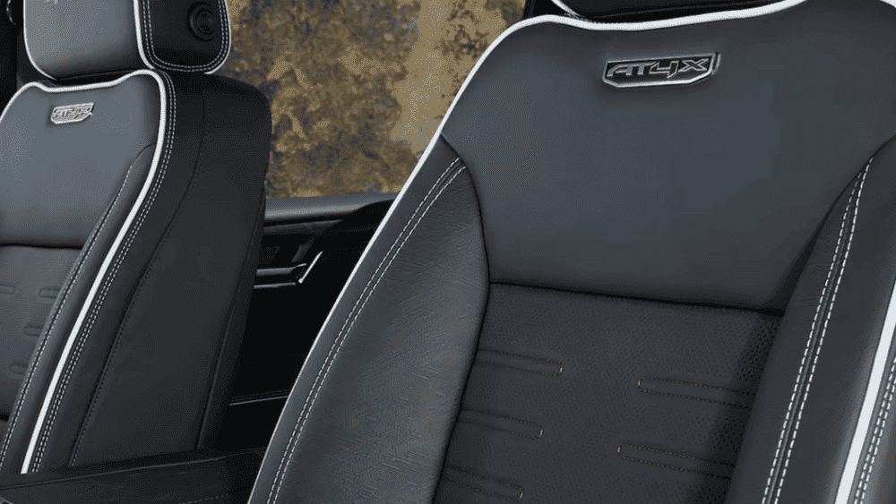 2026 GMC Sierra Heavy Duty AT4X seat detail near Ruth NC with black leather, AT4X badge, and red stitching