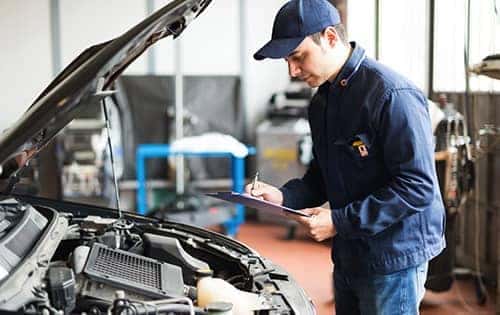 Mechanic checking engine of car