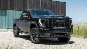 2024 GMC Sierra parked in a gravel drive way in front of a modern house