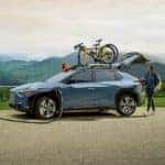 2023 Subaru Solterra EV SUV being plugged in and charged at an EV car charger