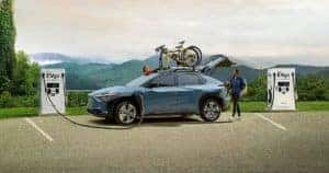 2023 Subaru Solterra EV SUV being plugged in and charged at an EV car charger