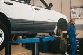 Man in blue working on a car