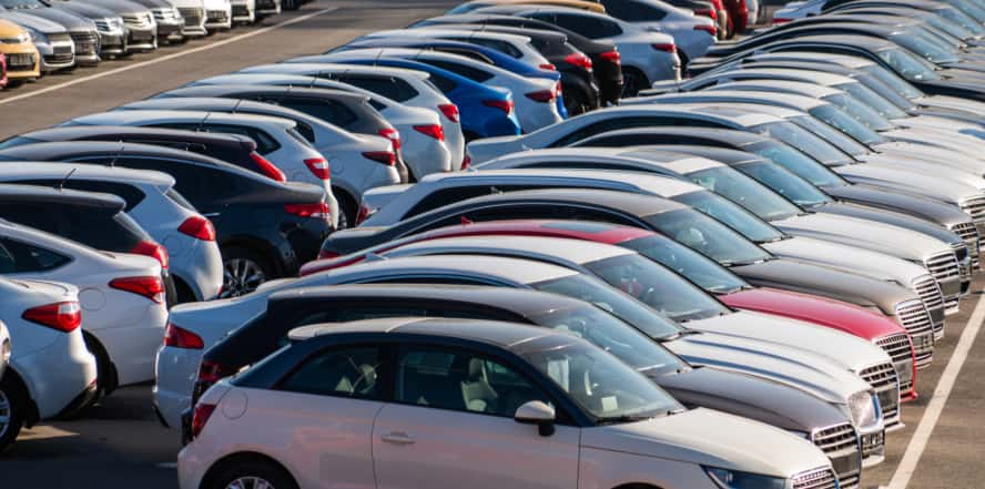 A long row of used cars at a dealership lot