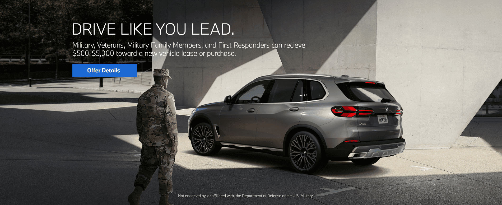 Service member standing next to BMW