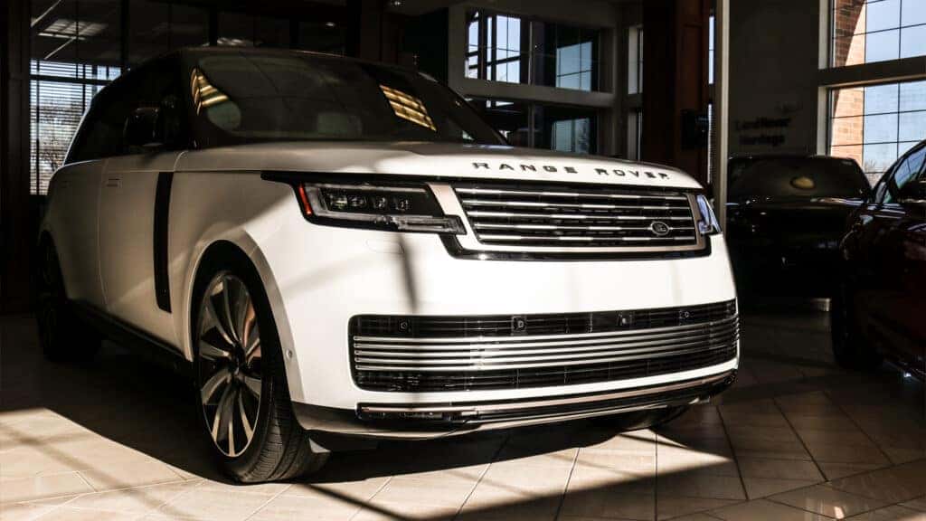 Front and side view of the 2025 Range Rover showcasing its sleek, modern design with clean lines, a distinctive grille, and premium LED headlights.