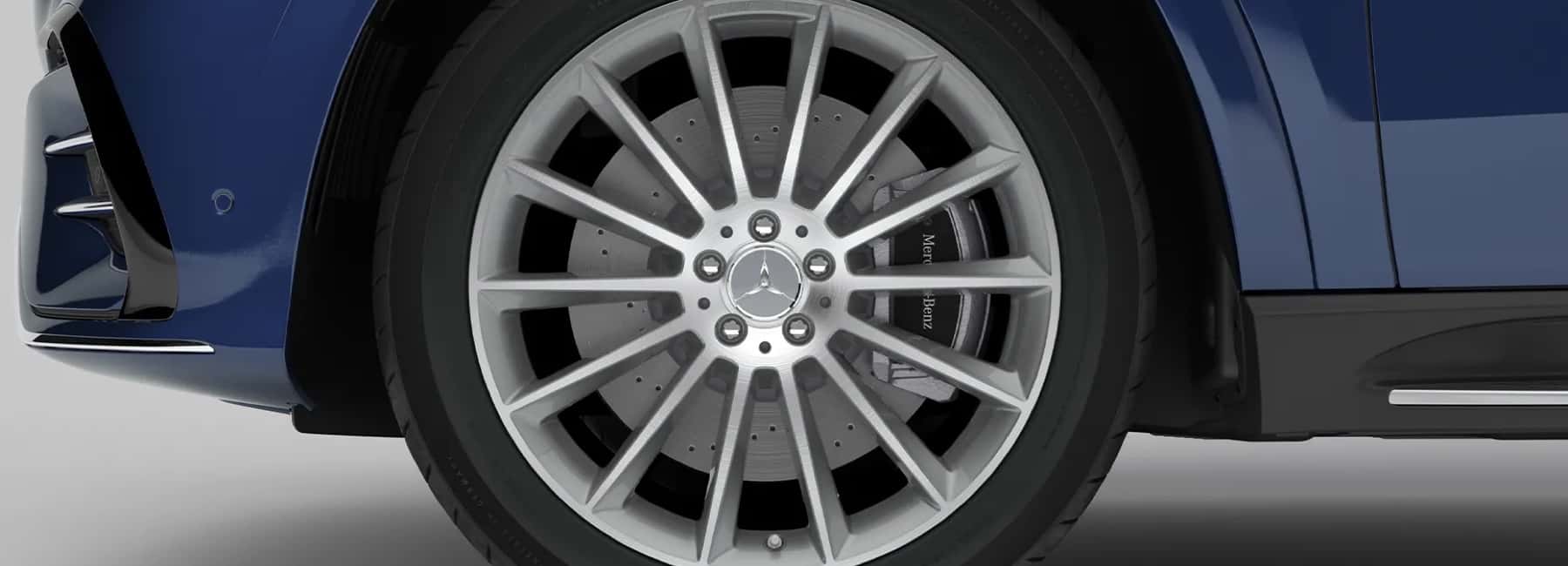 Close-up of a multi-spoke alloy wheel with a Mercedes-Benz center cap on a dark blue Mercedes-Benz, available through the parts team at Mercedes-Benz of Columbus North in Sunbury, Ohio