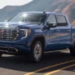 Blue 2024 GMC Sierra 1500 Denali driving to a GMC service center
