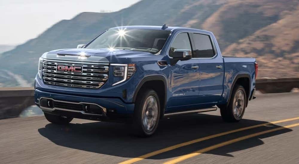 Blue 2024 GMC Sierra 1500 Denali driving to a GMC service center