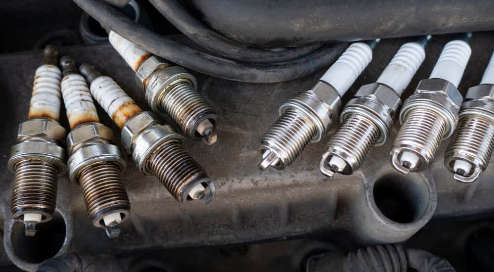 New and used spark plugs on an engine