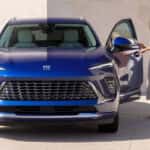 Woman exiting a blue 2025 Buick Envision after leaving a Buick service center near Florence