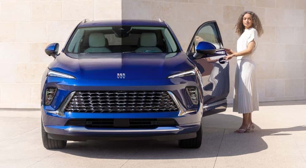 Woman exiting a blue 2025 Buick Envision after leaving a Buick service center near Florence