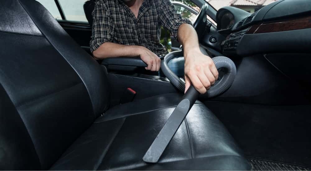 Person vacuuming a car