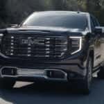 Black 2025 GMC Sierra 1500 Denali driving on a highway