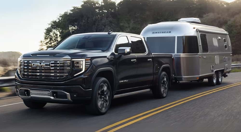 Black 2025 GMC Sierra 1500 Denali towing an Airstream trailer