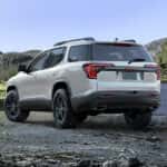 White 2023 GMC Acadia parked near a river