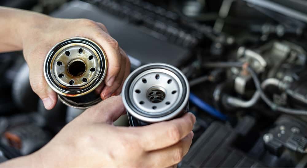 Mechanic holding a new and used oil filter