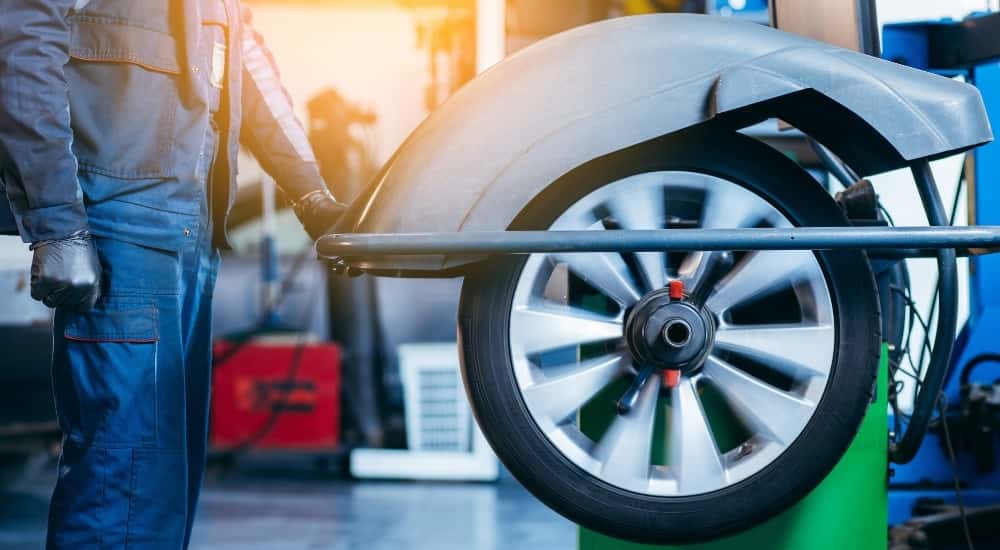 Technician using a tire balancing machine