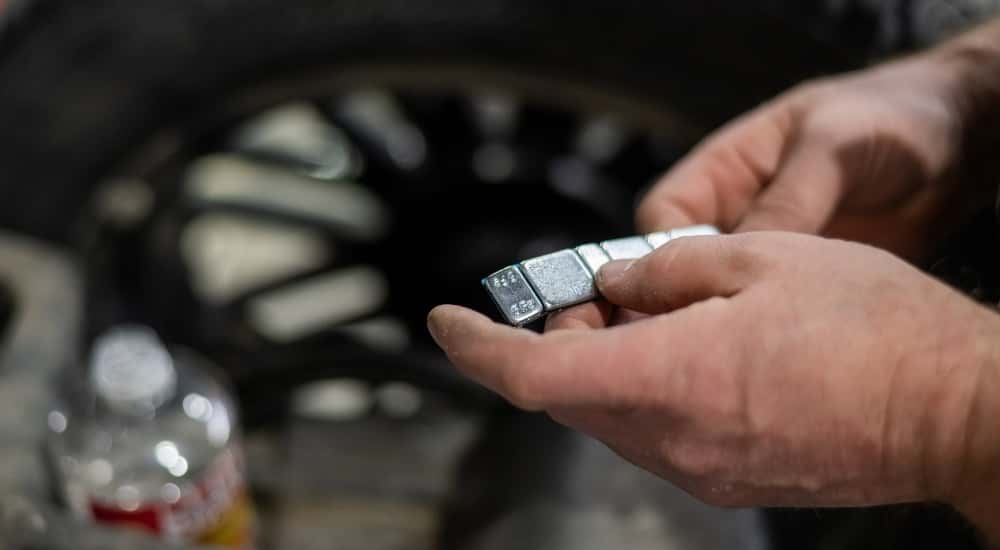 Technician holding wheel weights