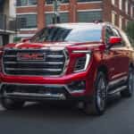 Red 2026 GMC Yukon Elevation driving to a GMC service center