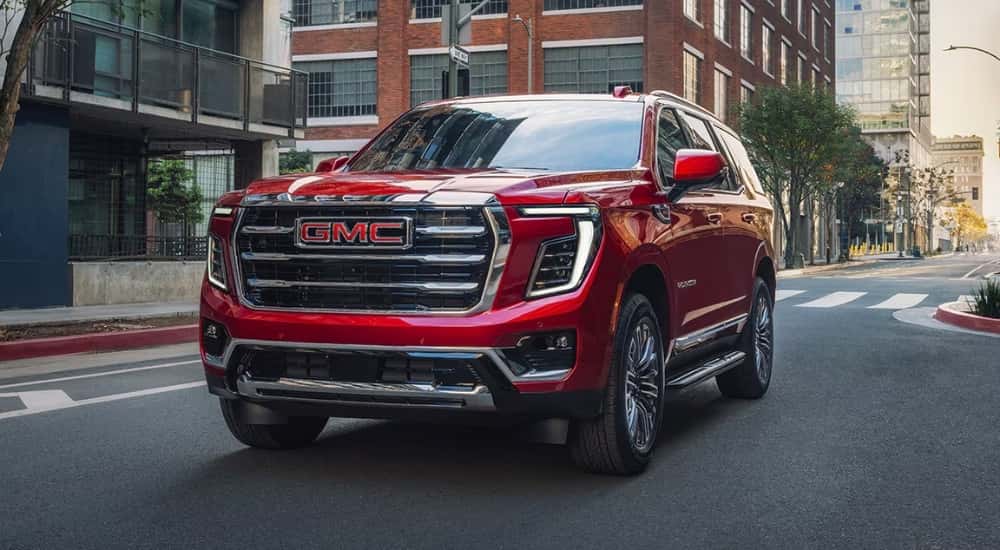 Red 2026 GMC Yukon Elevation driving to a GMC service center
