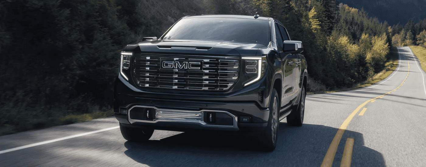 Black 2026 GMC Sierra 1500 Denali driving on an open road