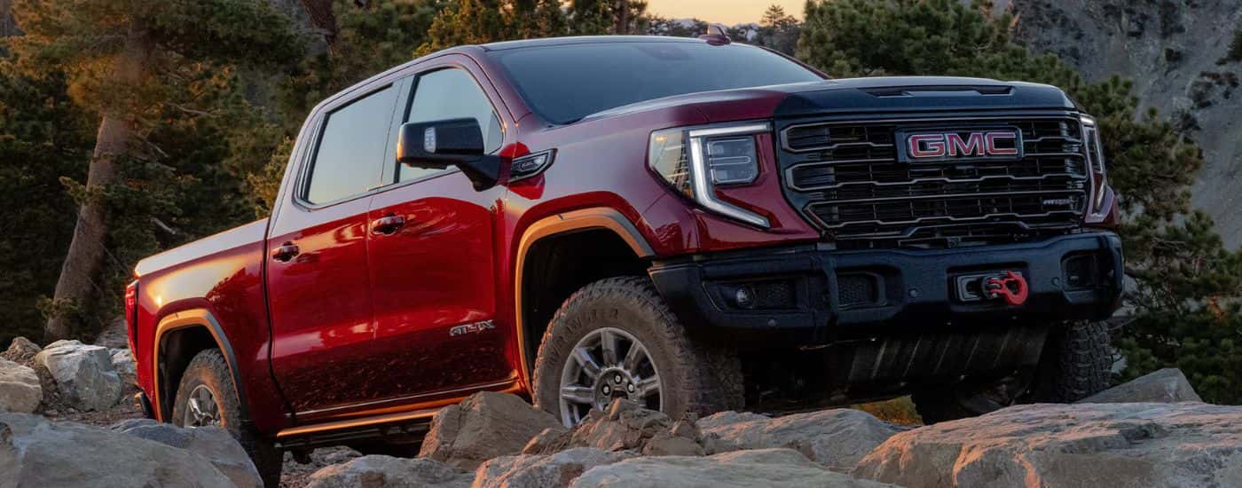 Red 2026 GMC Sierra 1500 driving over rocks