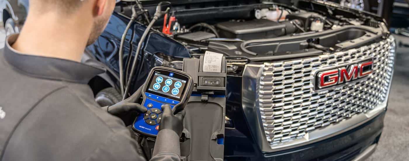 Technician testing a battery at a GMC service center