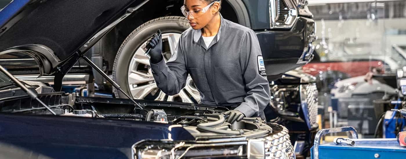 Technician diagnosing a vehicle at a GMC service center