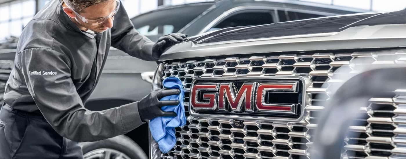 Technician cleaning a chrome grille