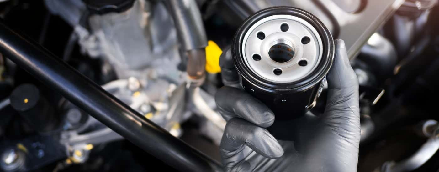 Technician holding an oil filter at a Buick service center near Monroe