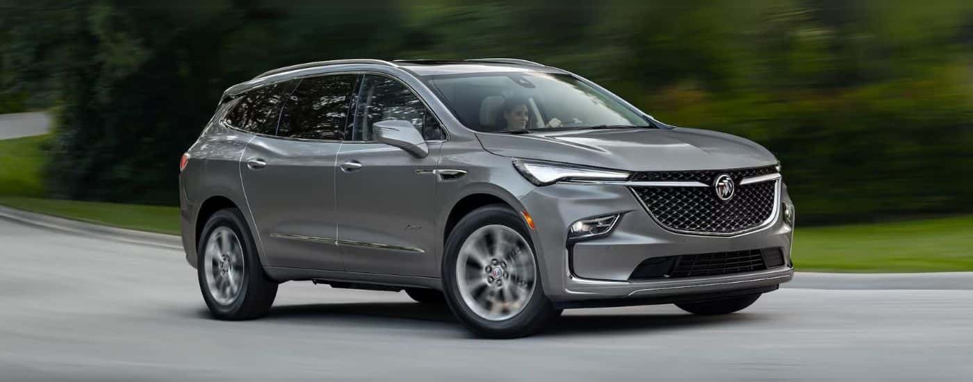 Grey 2024 Buick Enclave driving on the road.