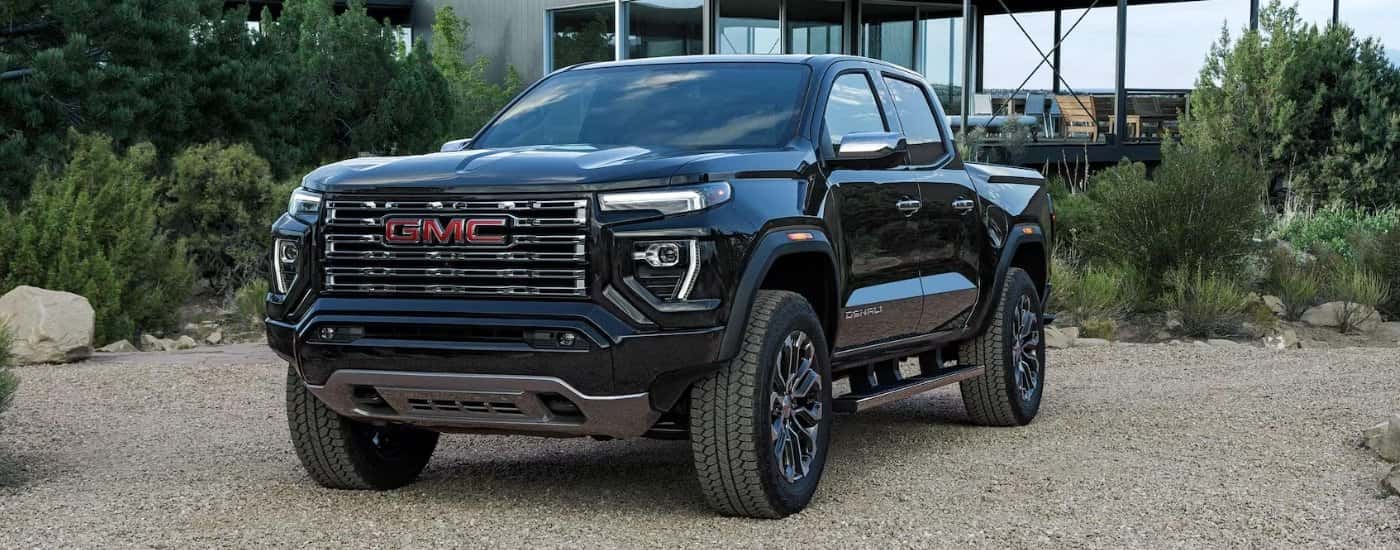 Black 2025 GMC Canyon Denali parked in front of a house