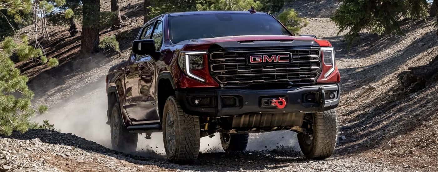 Red 2025 GMC Sierra 1500 AT4X driving to a GMC dealer near Florence