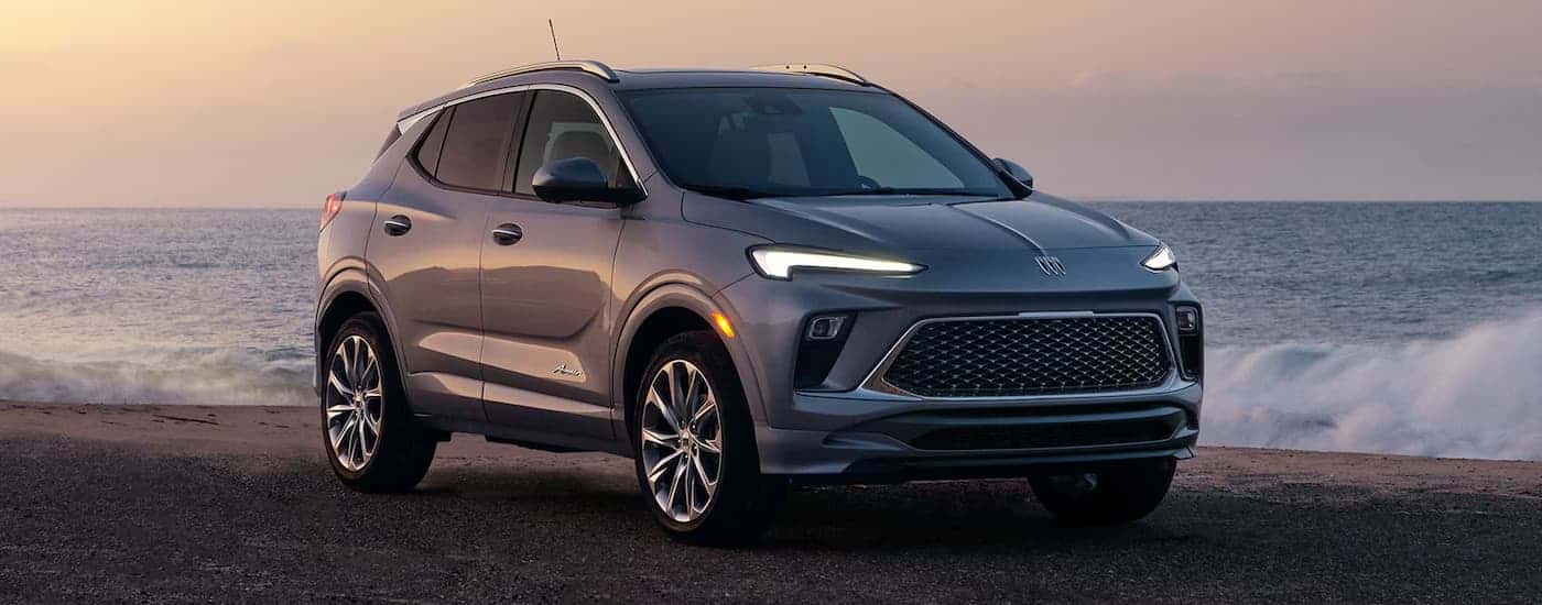 Grey 2026 Buick Encore GX parked off-road on a shore.