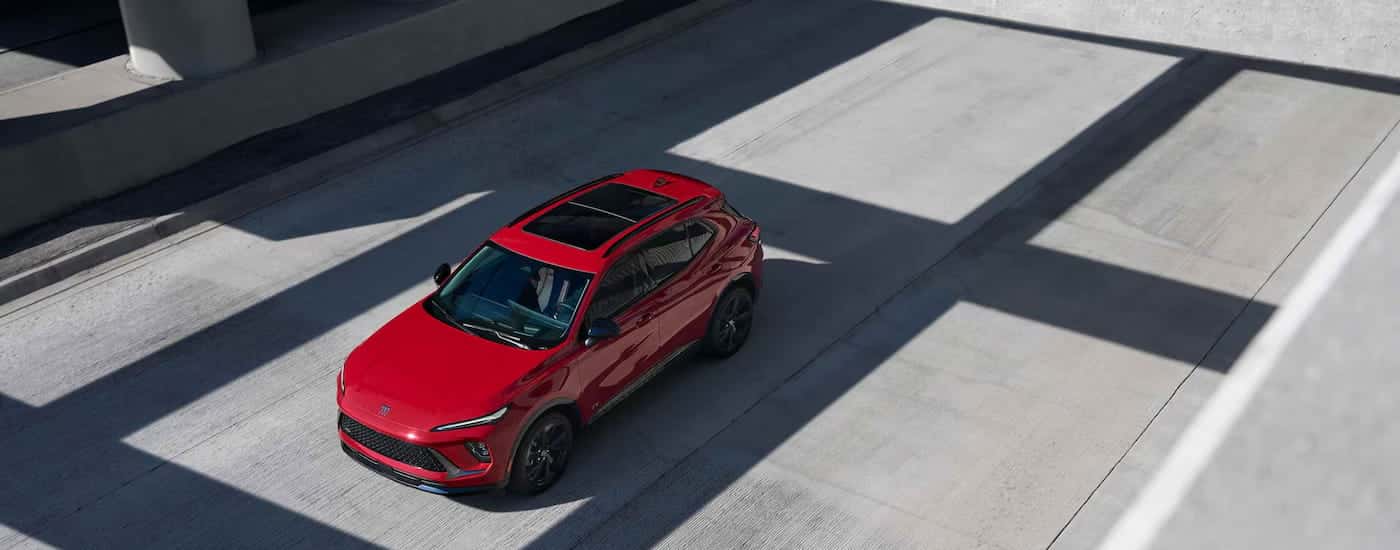 High view of a red 2026 Buick Envision driving down a road.
