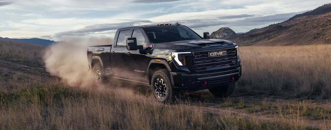 A black 2026 GMC Sierra 2500 driving offroad.