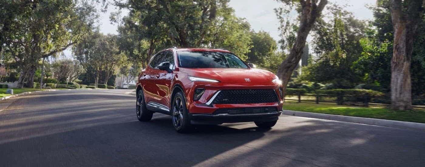 A red 2026 Buick Envision driving on a street.