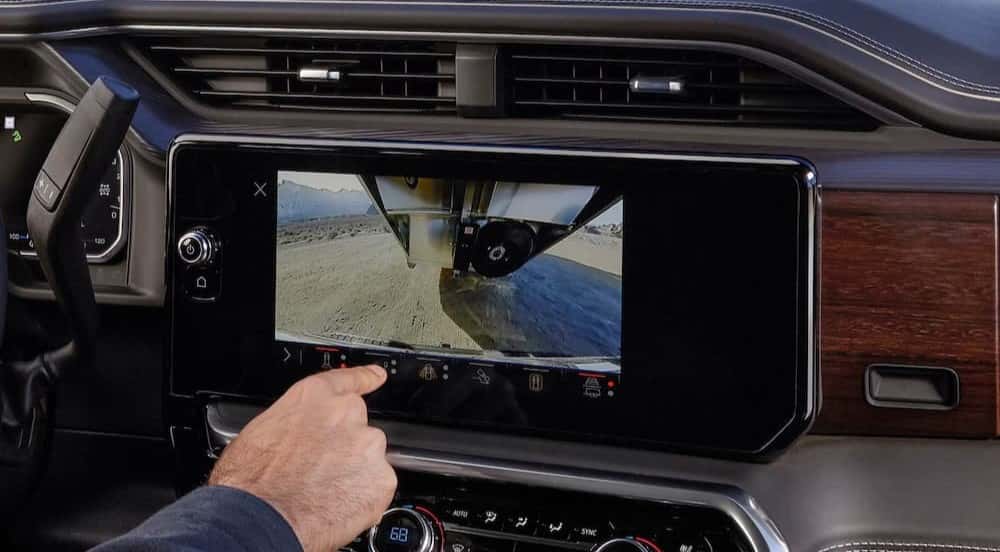 A person using the infotainment screen in a 2027 GMC Sierra 2500 HD.